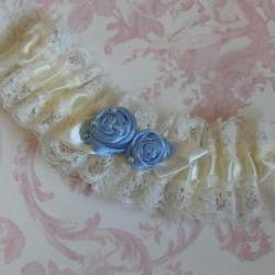 Ivory bridal garter with blue roses.